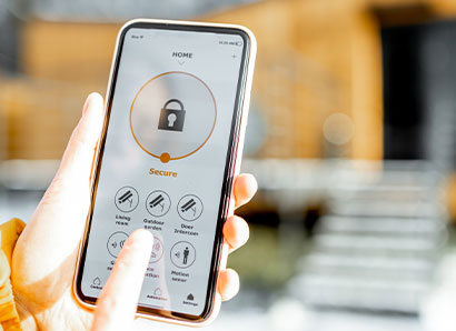 Phone with a finger selecting a camera in a home security app